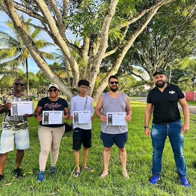 Turma de alunos exibindo os certificados após a aula prática ao ar livre